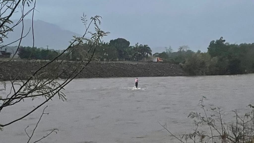 Motorista fica ilhado em cima de veículo após cair dentro de rio