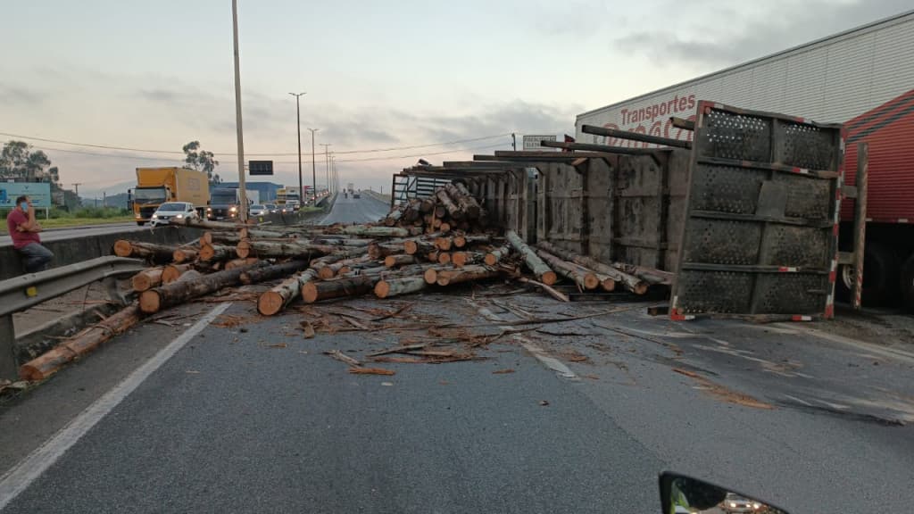 Carreta carregada de toras de madeira tomba na BR-101, em Itajaí e causa lentidão no trânsito