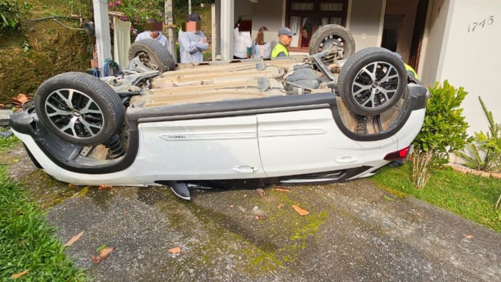 Carro com casal de idosos capota e cai sobre residência