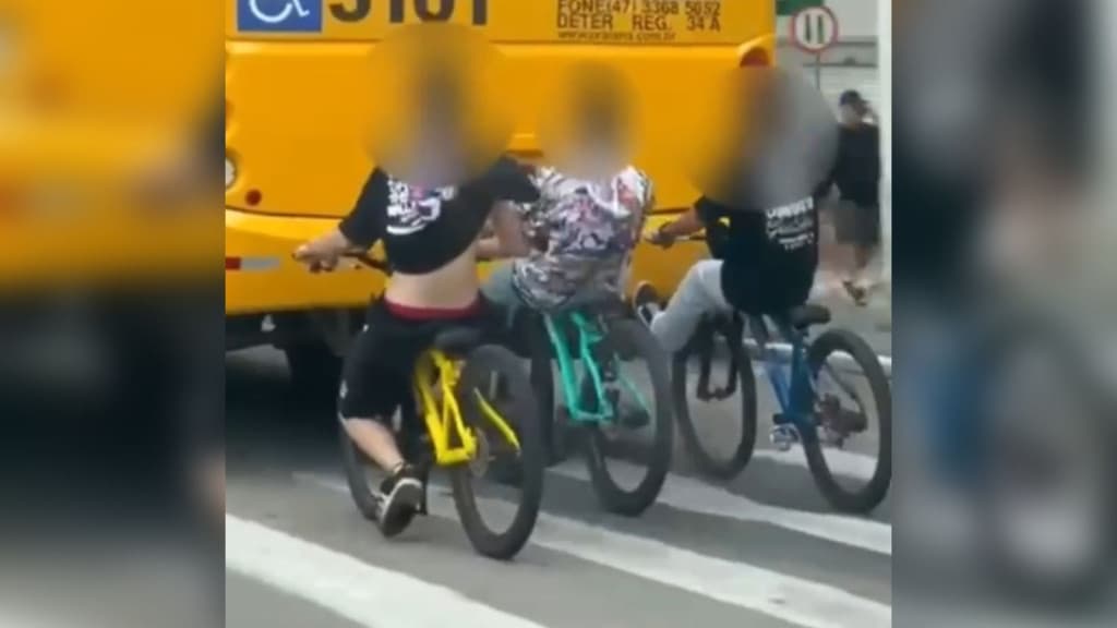 Jovens arriscam a vida de bicicleta pegando “rabeira” de ônibus em Itapema