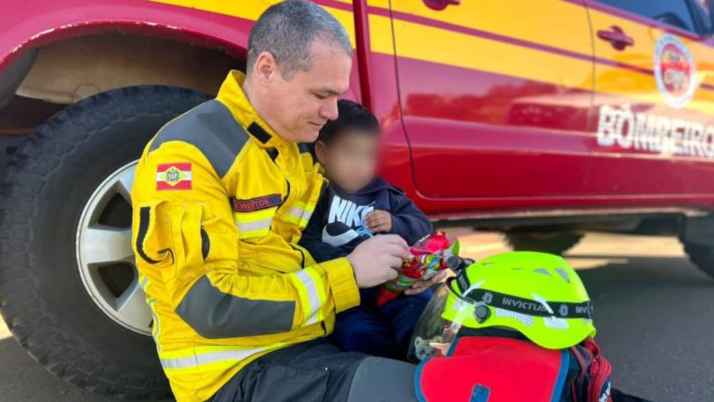 Bombeiro acalma criança após carro da família capotar em grave acidente