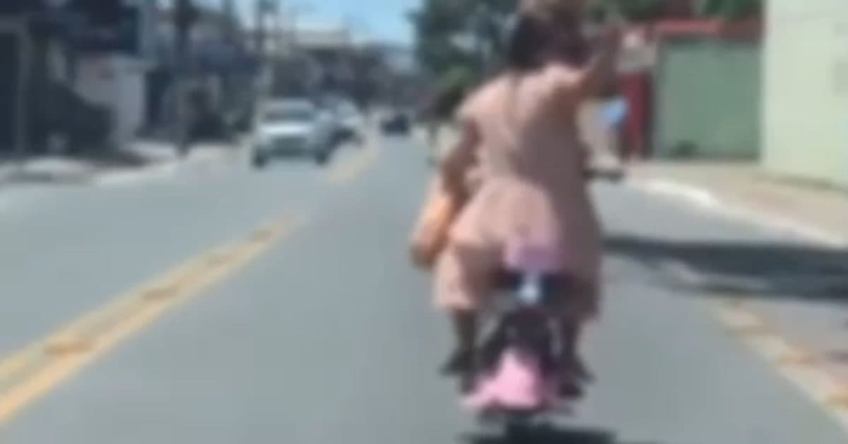 Mulher é flagrada em bicicleta elétrica no meio da rua com criança e mostra dedo do meio