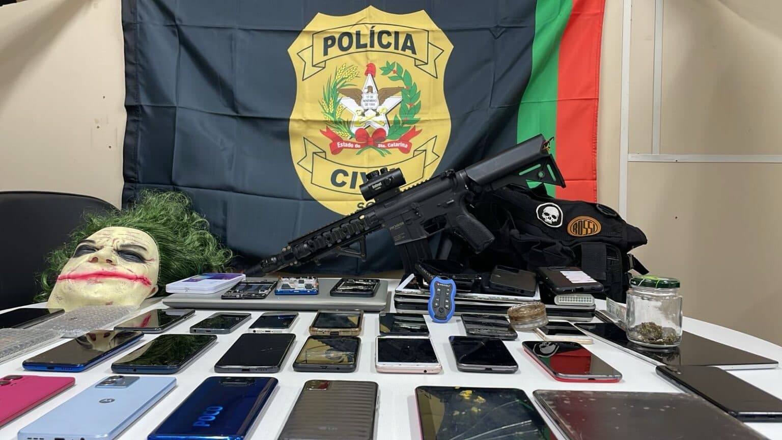 Polícia encontra réplica de fuzil e máscara do Coringa em casa com 22 celulares roubados