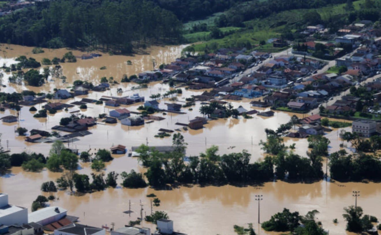 Vista aerea de cidade catarinense alagada apos enchente, com ruas e casas tomadas pela agua