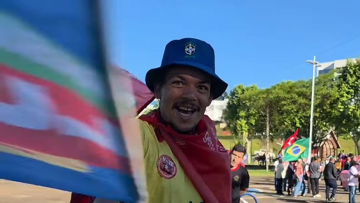 Apoiador do Lula ameaça jornalista e avança com bandeira até acertar a câmera durante ato do PT em SC