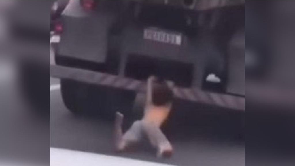 Criança é filmada pendurada na traseira de caminhão e quase é atropelada