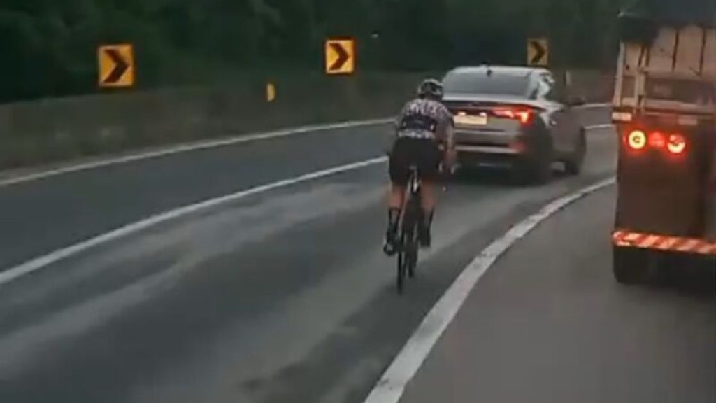 Ciclista se arrisca ao ultrapassar carreta no Morro do Boi, em Balneário Camboriú