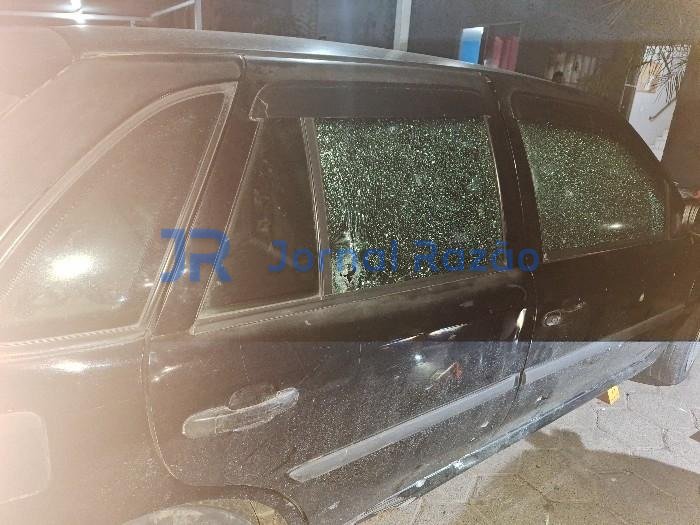 Volkswagen Gol preto com vidros estilhaçados por disparos em Joinville