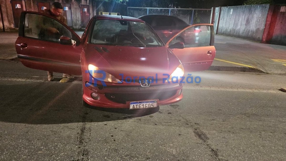 Peugeot 206 vermelho com as portas abertas sendo vistoriado pela Polícia Militar