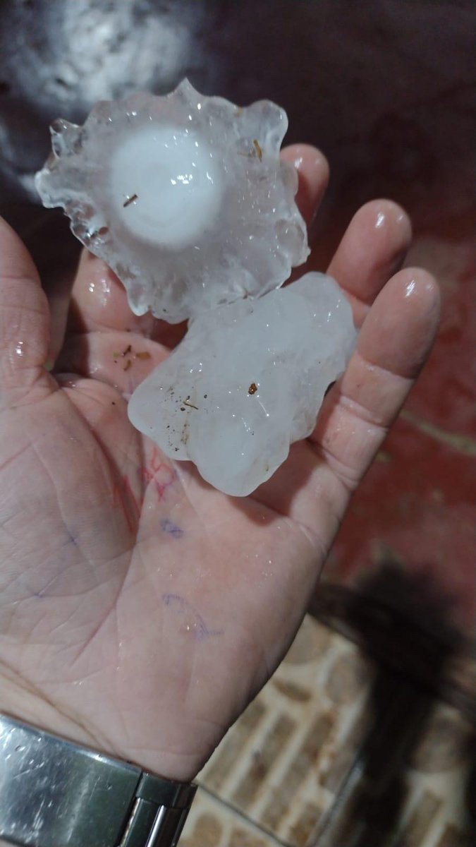 Pedras de granizo na mão de um morador