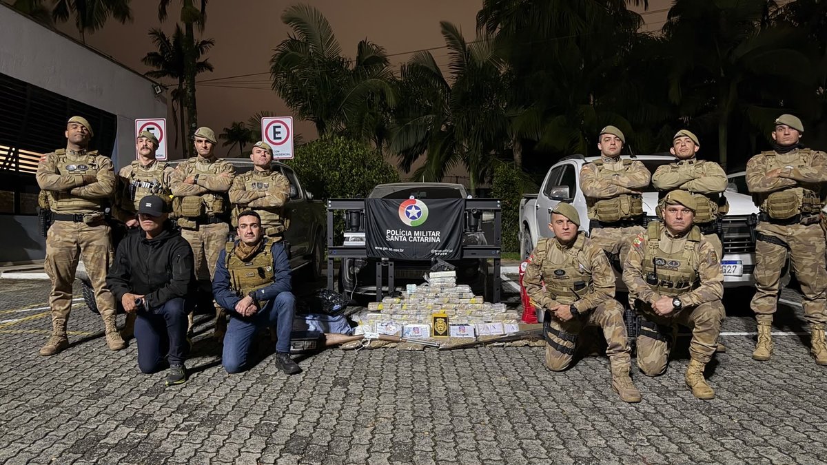 Policiais militares e federais ao lado da droga e das armas apreendidas em Araquari
