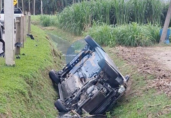Carro capotado dentro de vala com &aacute;gua na Estrada Geral da Itinga, em Tijucas