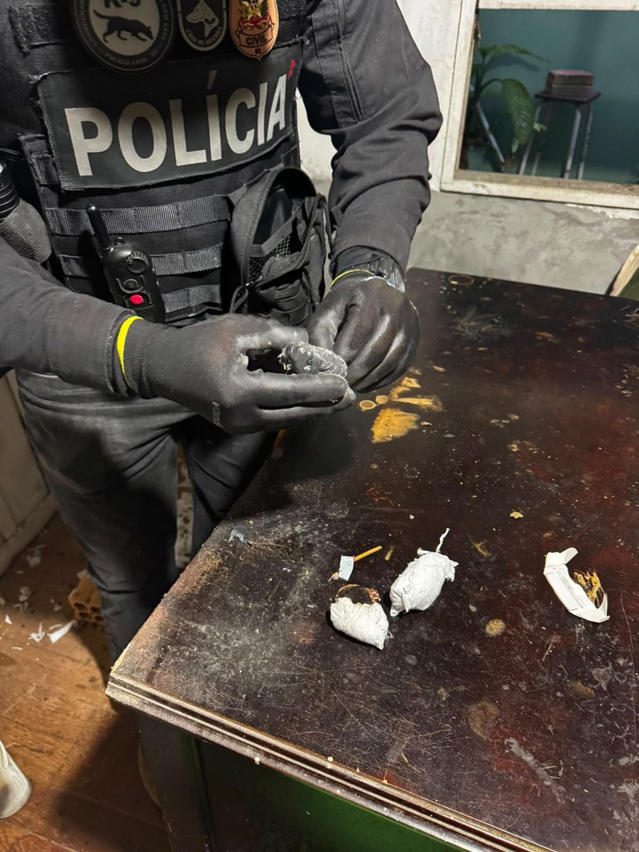 Policial civil manuseia porções fracionadas de entorpecentes sobre uma mesa