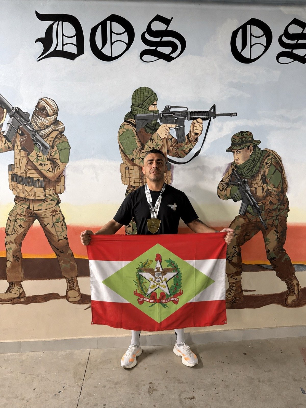 Rafael Sagaz com a bandeira de Santa Catarina na sede do BOPE, no Rio de Janeiro