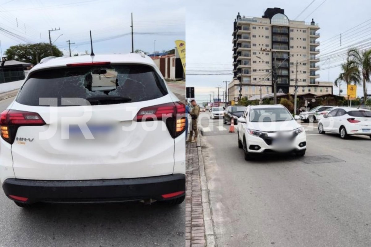 Vidro traseiro do HR-V branco com buraco no meio e a via onde ocorreu a batida, no Centro de Tijucas