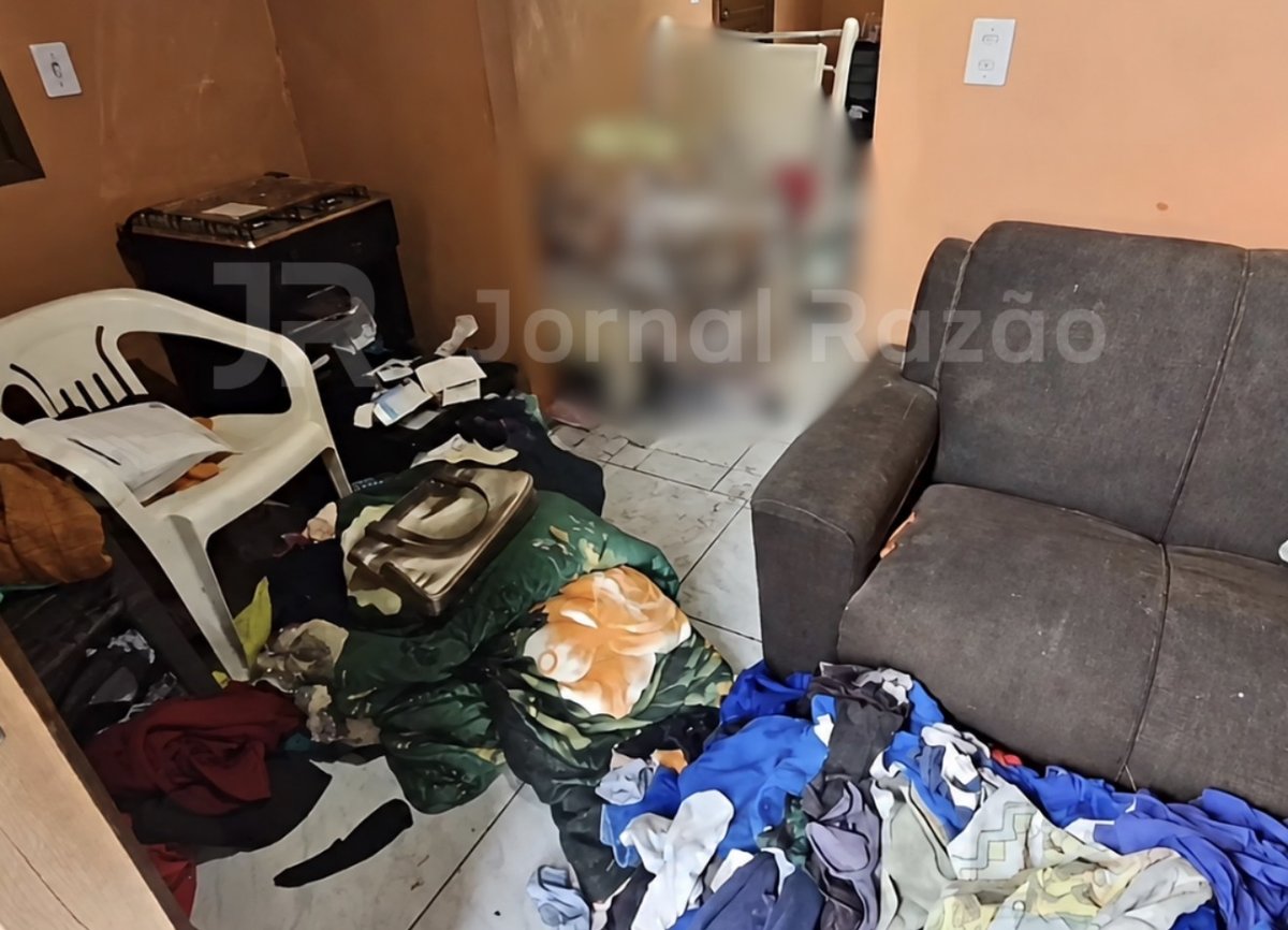 Sala da casa com roupas e objetos espalhados pelo chão