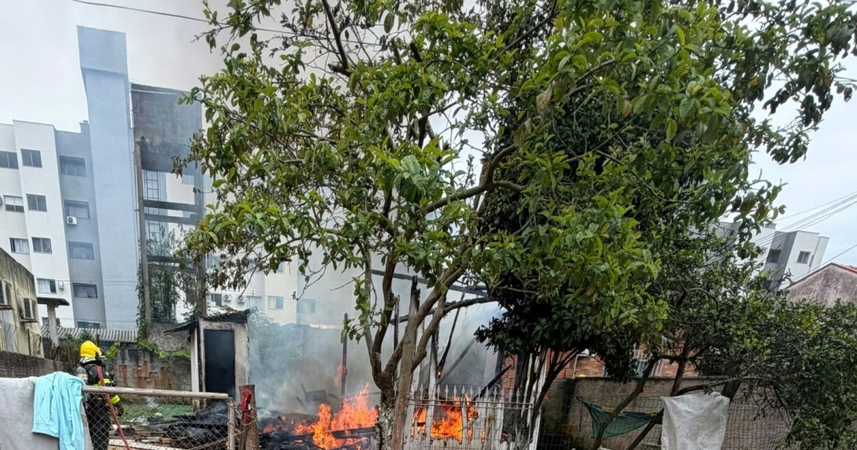 Incêndio toma casa de madeira e ameaça residência vizinha em Camboriú