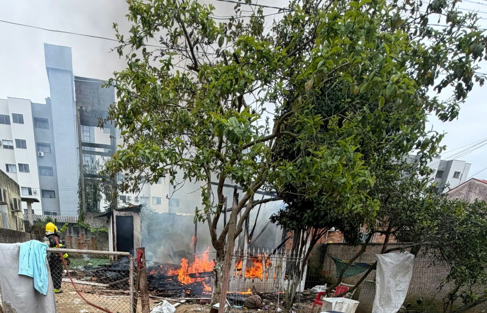 Incêndio toma casa de madeira e ameaça residência vizinha em Camboriú