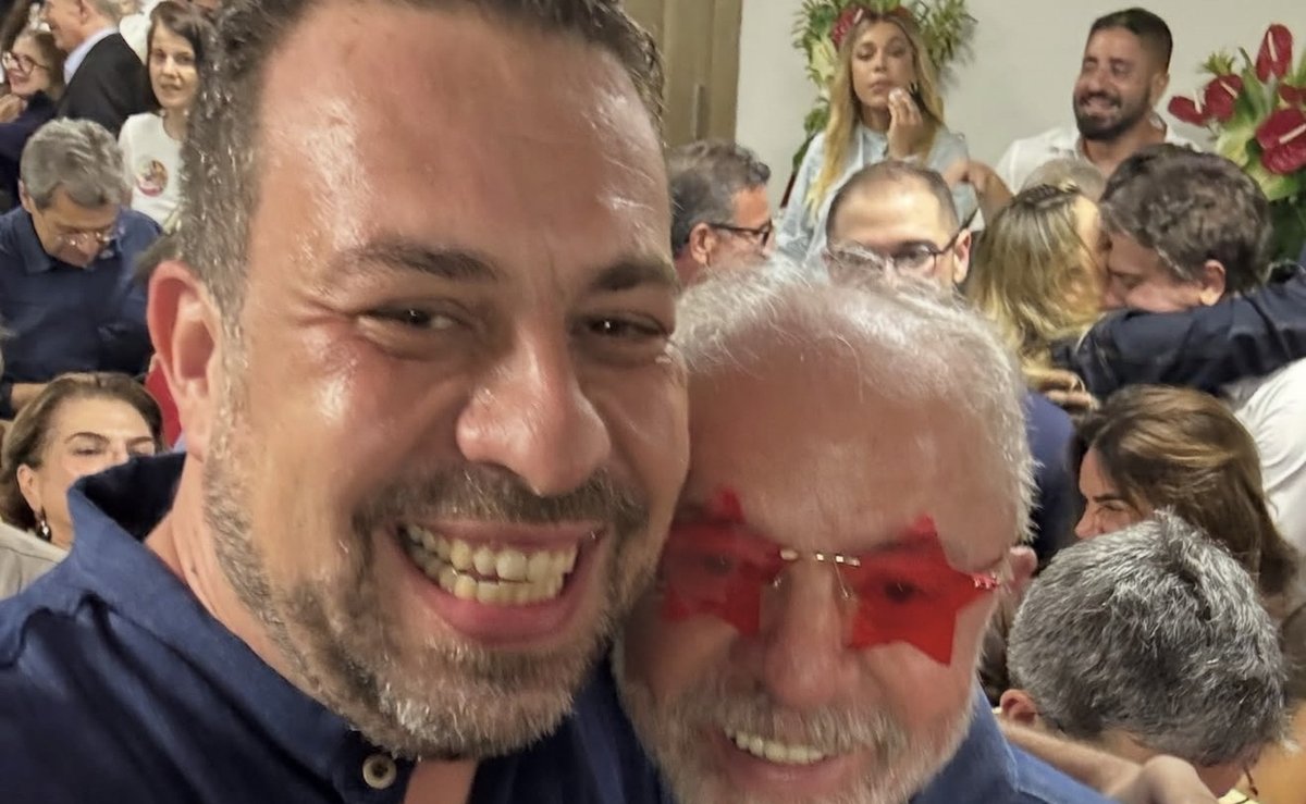 Guilherme Boulos grita na festa da reeleição e posa com Lula de óculos de estrela vermelha