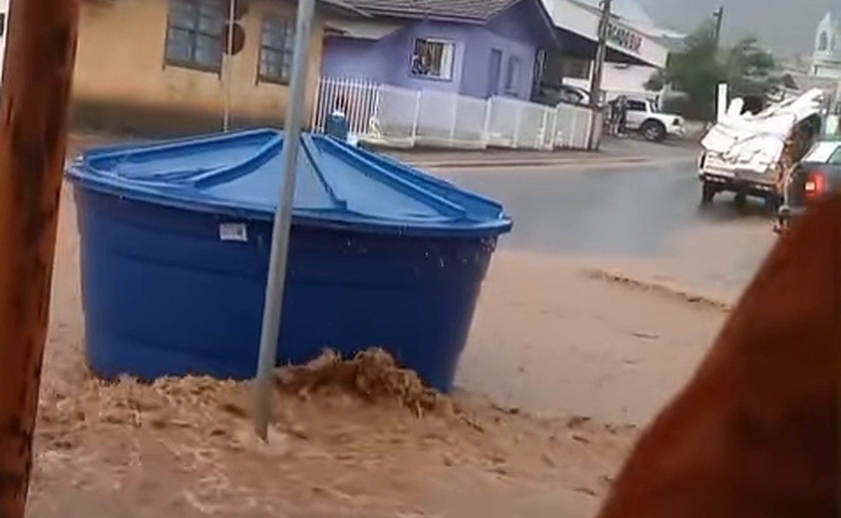 Enxurrada leva caixa d”água pela rua e invade lojas após chuva forte alagar o centro de cidade em SC