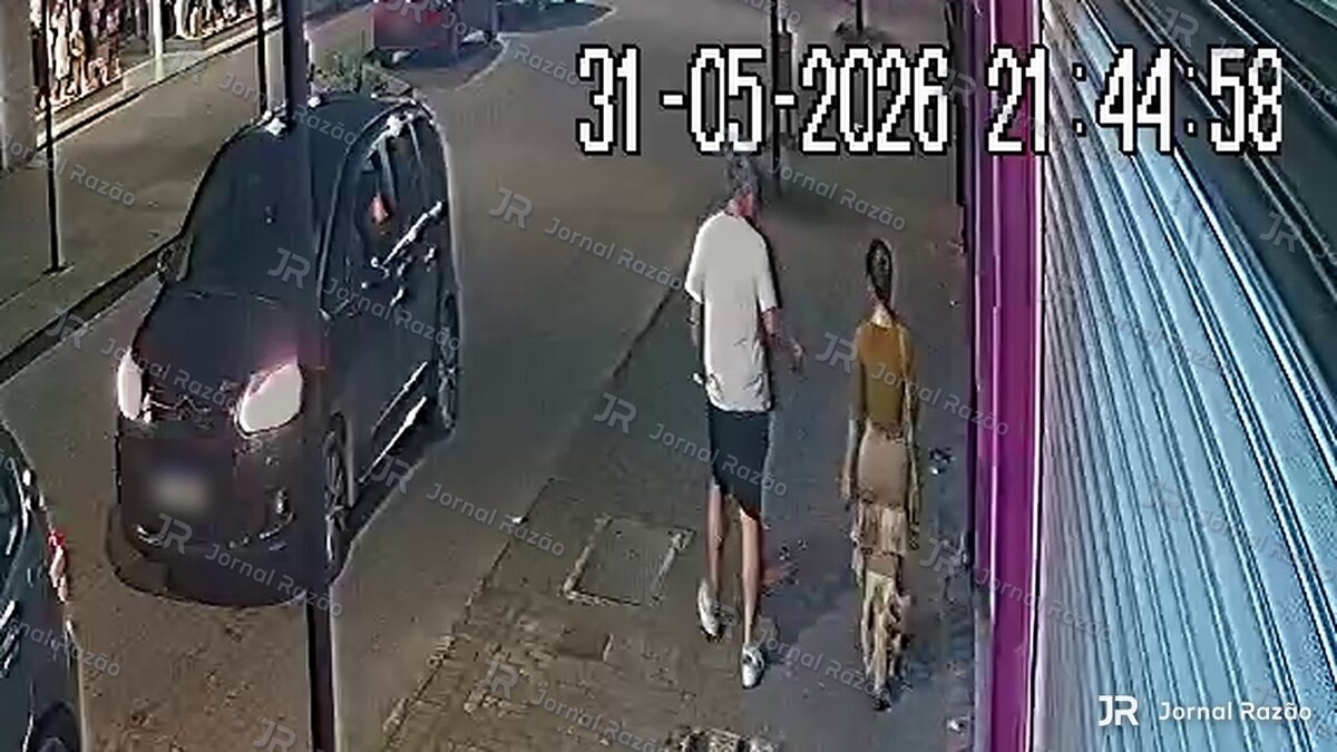 Fábio e Jaqueline caminham juntos em uma calçada de Blumenau, conforme o relógio da câmera às 21h44.